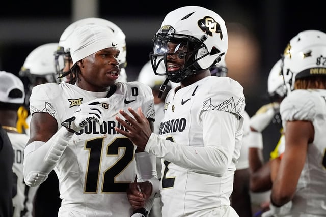 Colorado wide receiver Travis Hunter, left, confers with quarterback Shedeur Sanders in the second half of an NCAA college football game against Colorado State, Saturday, Sept. 14, 2024, in Fort Collins, Colo. (AP Photo/David Zalubowski)