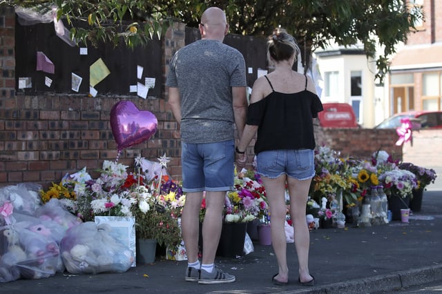 FILE - Floral tributes are left at the site in Southport, England, Sunday, Aug. 11, 2024 after three young girls were killed in a knife attack at a Taylor Swift-themed holiday club. (AP Photo/Scott Heppell, File)