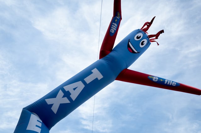 An inflatable advertising signs, dances outside of a tax preparer's office on April 15, 2024 in Chicago, Illinois. 