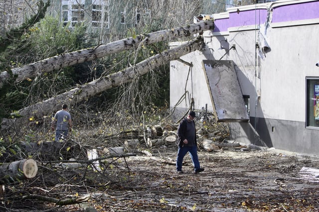 FILE - A crew cuts a tree that fell on a Taco Bell restaurant on Wednesday, Nov. 20, 2024, in Issaquah, Wash., after a "bomb cyclone" storm brought high winds to the area. (AP Photo/Manuel Valdes,File)
