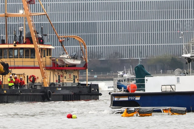 A crashed helicopter floating in front of an NYPD boat on the Hudson River on April 10, 202, seen from Jersey City, N.J.