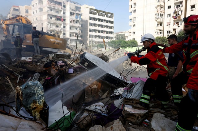 A member of the search and rescue team from the Lebanese Civil Defense sprays water from a hose at the site of an Israeli strike, in Beirut southern suburbs, Lebanon, March 28, 2025. REUTERS/Mohamed Azakir/File Photo