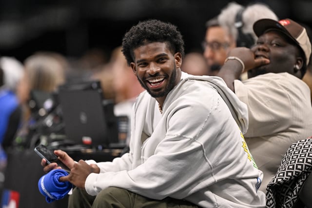 Jan 14, 2025; Dallas, Texas, USA; Colorado Buffaloes quarterback Shedeur Sanders laughs as he watches the game between the Dallas Mavericks and the Denver Nuggets during the second half at the American Airlines Center. Mandatory Credit: Jerome Miron-Imagn Images/ File Photo