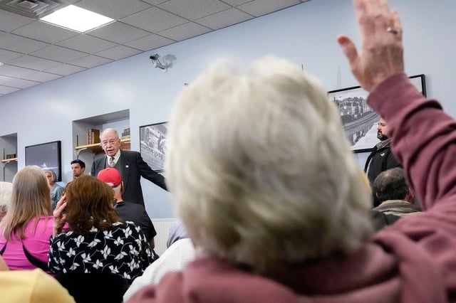 A constituent raises her hand to ask Sen. Chuck Grassley a question during a town hall April 15 in Fort Madison, Iowa.