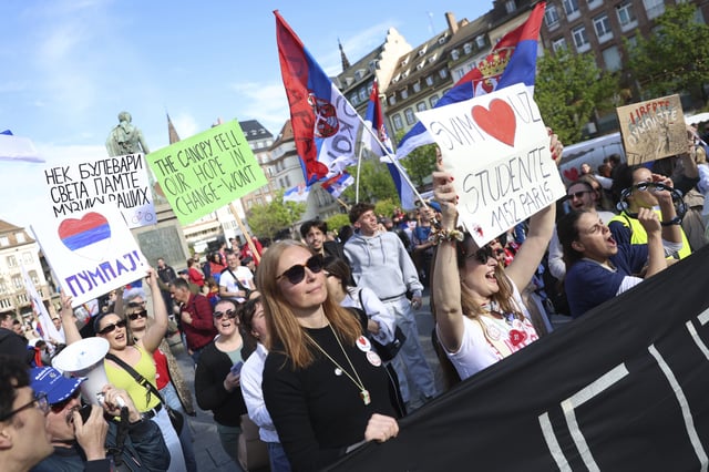 Protesters hold signs before Serbian university students riding bicycles from Novi Sad, Serbia, and who say are fighting for justice and the rule of law, arrive the heart of the European Union to seek support, Tuesday, April 15, 2025 in Strasbourg, eastern France. (AP Photo/Antonin Utz)