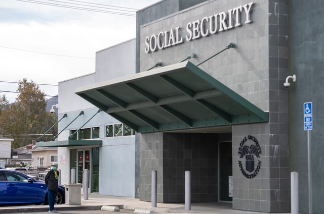 A person wearing a facemask stands outside a US Social Security Administration building, November 5, 2020, in Burbank, California.