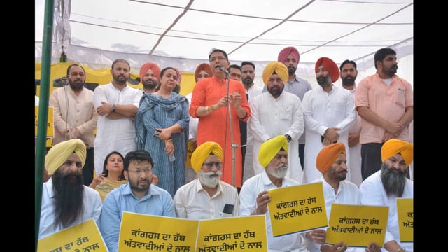 Punjab Aam Aadmi Party (AAP) president Aman Arora staging a dharna in front of a police station to demand action against leader of Opposition Partap Singh Bajwa. (HT)
