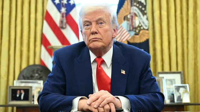 US President Donald Trump looks on after signing an executive order in the Oval Office of the White House.