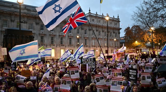 Protesters wave Israeli flags and hold photos of people held hostage by Hamas in Gaza during a demonstration outside the prime minister's offices in London, Nov. 19, 2023. (Justin Tallis/AFP via Getty Images)