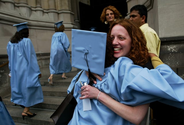 A graduate of Columbia University&#39;s lauded School of International and Public Affairs (SIPA) gets a hug from a friend outside SIPA&#39;s commencement exercises at St. John the Divine cathedral May 17, 2004 in New York City.