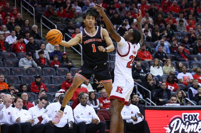 Xaivian Lee #1 of the Princeton Tigers passes the ball while being defended by Jeremiah Williams #25 of the Rutgers Scarlet Knights during the first half at Prudential Center on Dec. 21, 2024 in Newark, New Jersey. (Photo by Ed Mulholland/Getty Images)