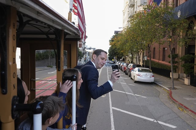 FILE - Mayor-elect Daniel Lurie, right, takes a photograph of his family while riding a cable car, before being inaugurated into office Wednesday, Jan. 8, 2025, in San Francisco. (AP Photo/Godofredo A. Vásquez, File)