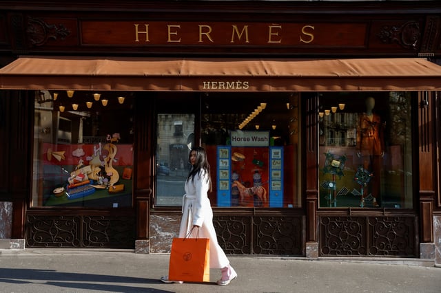 A woman walks in front of a Hermes store in Paris, France February 14, 2025. REUTERS/Abdul Saboor/File Photo