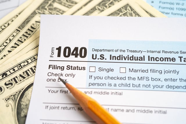Stock image/file photo: IRS tax return forms and U.S. Dollars.