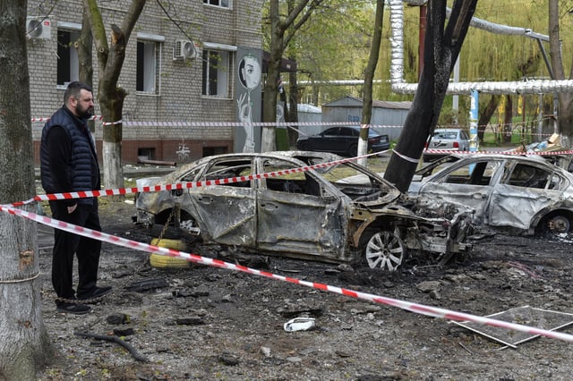 A resident stands next to burned cars at the site of a Russian drone strike, amid Russia's attack on Ukraine, in Dnipro, Ukraine April 17, 2025. REUTERS/Mykola Synelnykov