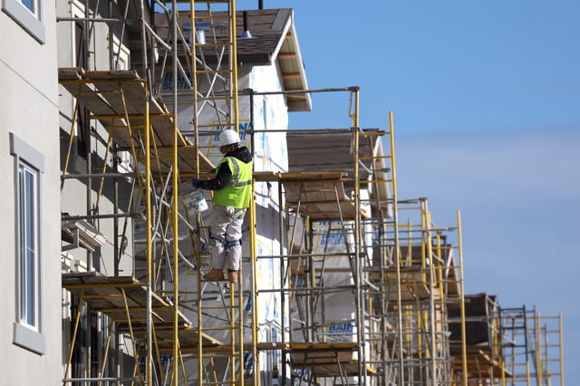 A worker makes repairs to a home under construction.