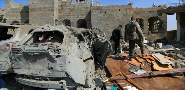 Des rebelles houthis inspectent un site au lendemain d'une frappe aérienne américaine à Sanaa, le 7 avril 2025 au Yémen