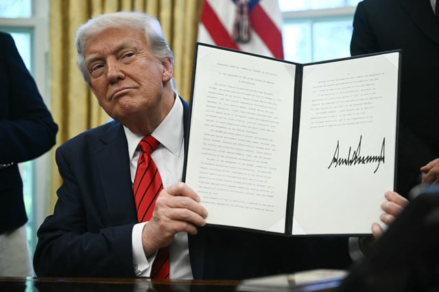President Donald Trump displays a proclamation expanding fishing rights in the Pacific islands he signed in the Oval Office of the White House in Washington, DC, on April 17, 2025.