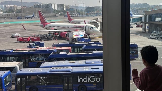 A boy looks at Air India airline passenger aircraft parked at the Chhatrapati Shivaji Maharaj International Airport in Mumbai.