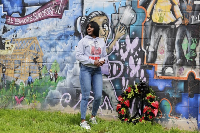 Fredricka Gray, twin sister of Freddie Gray, lays a wreath at a mural during a memorial event commemorating the ten-year anniversary of her brother's death, Saturday, April 19, 2025, in Baltimore. (AP Photo/Stephanie Scarbrough)