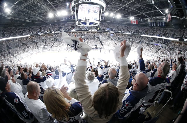 Fans celebrate Winnipeg Jets' Morgan Barron's goal against the St. Louis Blues during first period NHL playoff action in Winnipeg on Saturday, April 19, 2025. THE CANADIAN PRESS/John Woods