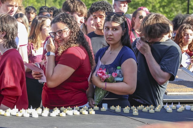 The day after an active shooter on campus Florida State students place electronic candles on a platform during a vigil on campus at Langford Green, Tallahassee, Fla., Friday, April 18, 2025. (AP Photo/Gary McCullough)