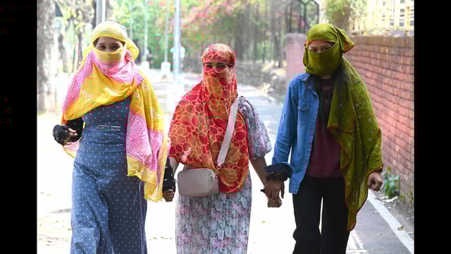 Women cover themselves with scarves to beat the heat amid rising temperatures in Chandigarh on Sunday. (Keshav Singh/HT)