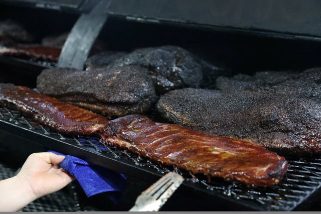 A staff member shows U.S. pork and beef in a smokehouse at Home Plate BBQ, an American-style restaurant, in Beijing, China April 17, 2025. REUTERS/Tiffany Le