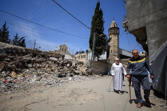 Palestinians walk past a damaged church after the death of Pope Francis was announced by the Vatican, in Gaza City April 21, 2025. REUTERS/Dawoud Abu Alkas