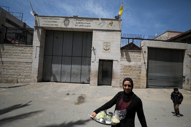 A Palestinian woman walks outside the Holy Family Church after the death of Pope Francis was announced by the Vatican, in Gaza City April 21, 2025. REUTERS/Dawoud Abu Alkas