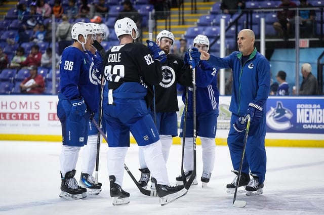 Vancouver Canucks head coach Rick Tocchet, right, talks as Ian Cole (82), Andrei Kuzmenko (96), Elias Pettersson, back left, Filip Hronek, back centre, and Nils Hoglander, back right, listen during the opening day of the NHL hockey team's training camp, in Victoria, Thursday, Sept. 21, 2023. THE CANADIAN PRESS/Darryl Dyck