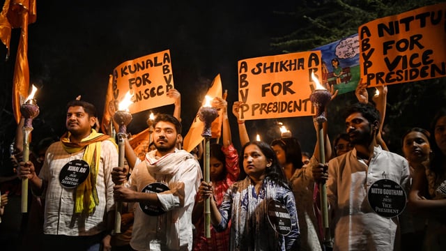 Akhil Bharatiya Vidyarthi Parishad (ABVP) supporters take part in a Mashaal Juloos, at JNU Campus in New Delhi on Monday.