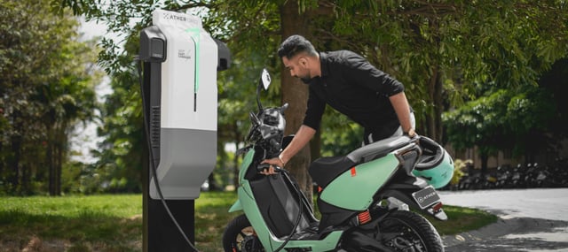 Man charging electric motor scooter