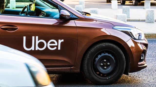 Uber car in traffic, modern city taxi service in Bucharest, Romania, 2019