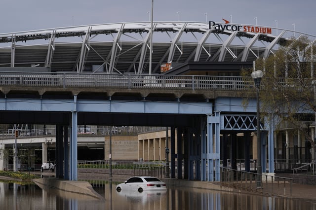 The Paycor Stadium, home of the Cincinnati Bengals NFL football team, is seen behind a Mercedes-Benz abandoned in Ohio River floodwaters at he base of the John A. Roebling Suspension Bridge, Wednesday, April 9, 2025, in Cincinnati. (AP Photo/Carolyn Kaster)
