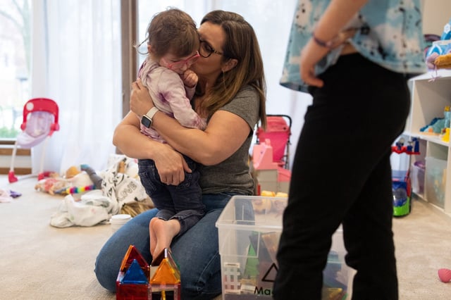 Carrie Mangoubi holds her daughter, Mia Mangoubi, 3, after playing with building tiles in their home on April 18, 2025, in Northbrook. The Mangoubis were among those who survived the Highland Park Independence Day parade mass shooting in 2022. (Audrey Richardson/Chicago Tribune)