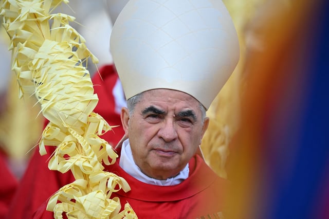 Italian Cardinal Giovanni Angelo Becciu takes par in the procession of the Palm Sunday mass on April 2, 2023 at St. Peter's square in The Vatican.