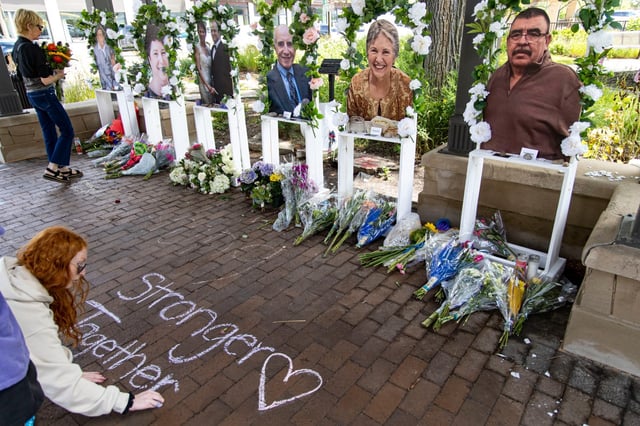Residents deliver flowers and leave chalk messages at a memorial depicting the seven victims near the Central Avenue scene, July 7, 2022, three days after a mass shooting at the Fourth of July parade in Highland Park. (Brian Cassella/Chicago Tribune)