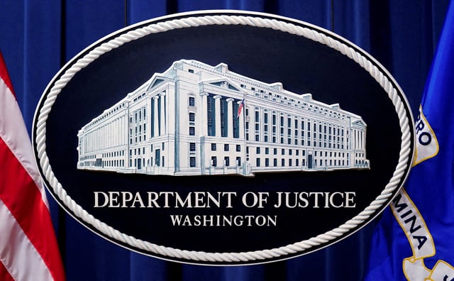 A U.S. Justice Department logo or seal showing Justice Department headquarters, known as "Main Justice," is seen behind the podium in the Department's headquarters briefing room, January 24, 2023.  REUTERS/Kevin Lamarque/File Photo