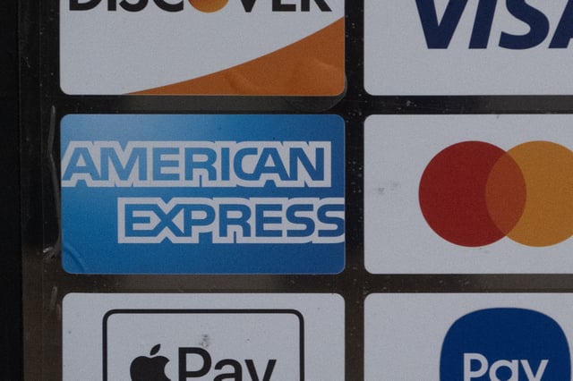 A sticker shows that the American Express credit card is accepted at the front of a business on February 11, 2025 in Chicago, Illinois.