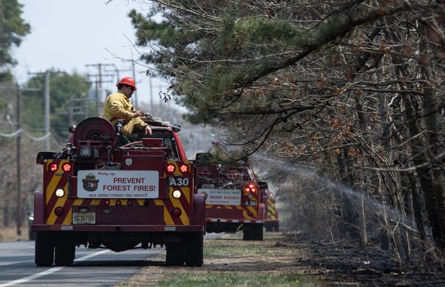 New Jersey Forest Fire Service fire crews work to extinguish the Jones Road Fire near Lacey Township in Ocean County, New Jersey, on April 23, 2025.