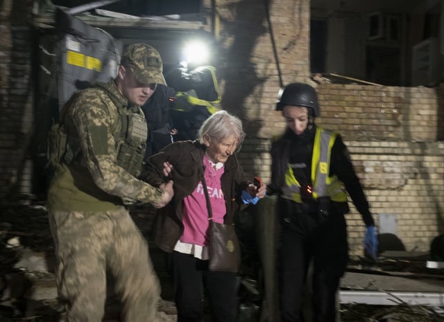 Rescatistas ucranianos ayudan a los supervivientes a salir del lugar donde un cohete alcanzó un edificio residencial en Kiev.