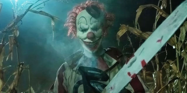 Clown in a Cornfield - Frendo holding a chainsaw