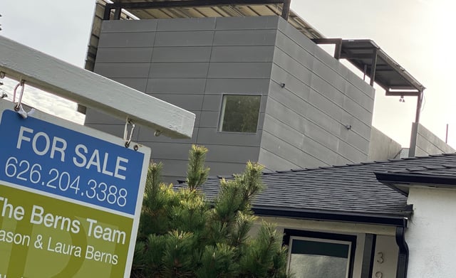 A real estate sign is seen in front of a house for sale in West Los Angeles on November 20, 2020.