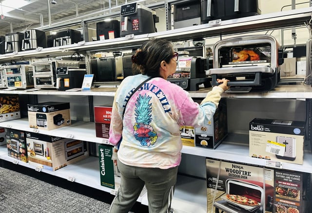 A woman takes a look at the interior of a kitchen appliance at an electronics and appliances retailer in Montebello, Calif., on April 16, 2025.