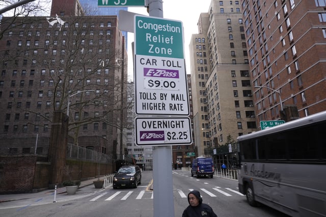 FILE - Signs advising drivers of congestion pricing tolls are displayed near the exit of the Lincoln Tunnel in New York, Wednesday, Feb. 19, 2025. (AP Photo/Seth Wenig, File)