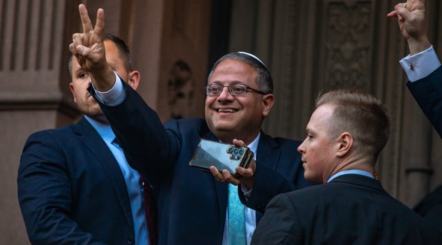 Israel's national security minister Itamar Ben-Gvir flashes a peace sign at a crowd of protesters near Yale University's campus in New Haven, Connecticut, April 23, 2025. Shabtai, a Jewish society at Yale, was one of the few groups to publicize a meeting with him on his US tour. (Photo by Yakov Binyamin)