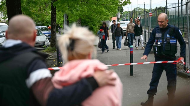 Eltern und Schüler stehen vor einer wegen eines Messerangriffs abgesperrten Schule in Nantes
