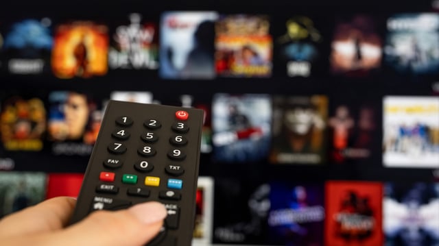 Woman hand holding tv remote.