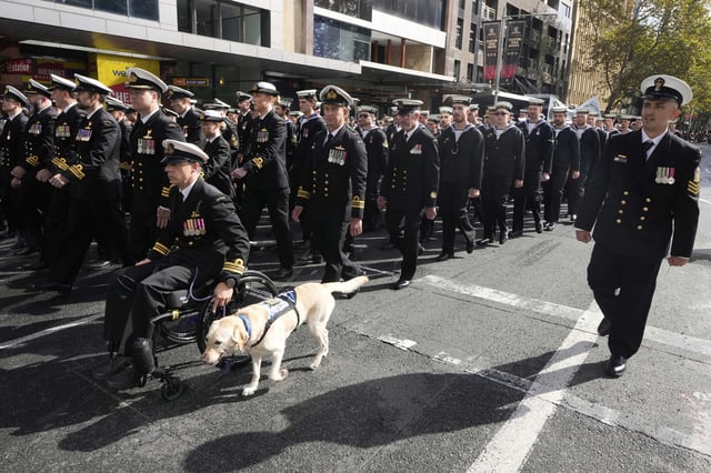 Participants march as thousands of people line the street to pay tribute to their war dead during the Anzac Day parade in Sydney, Australia, Friday, April 25, 2025. (AP Photo/Rick Rycroft)